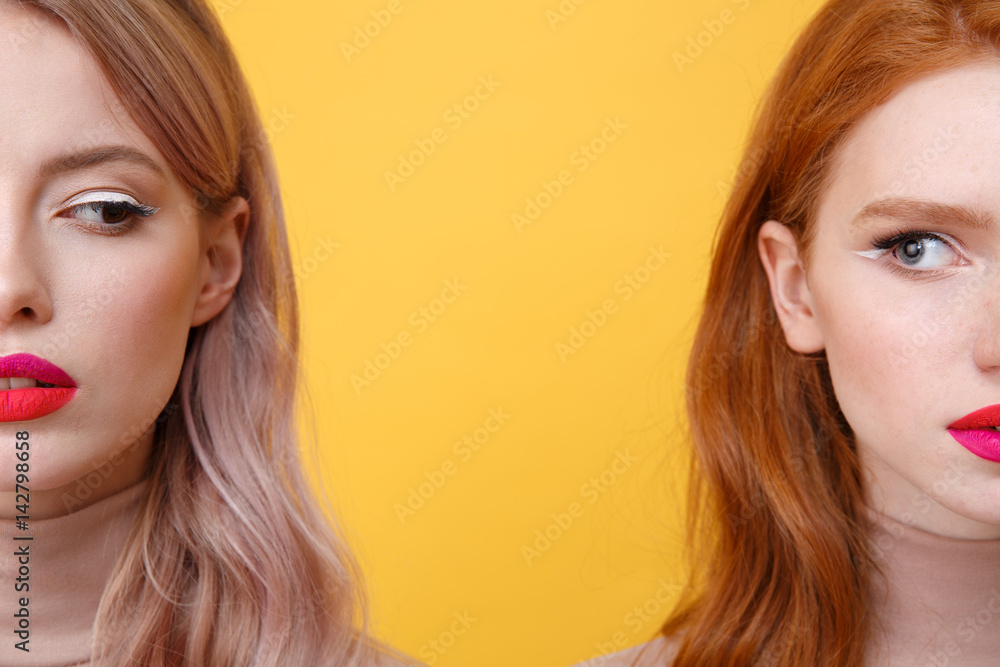 Cropped photo of young serious two ladies with bright makeup Cropped photo of young serious two ladies with bright makeup