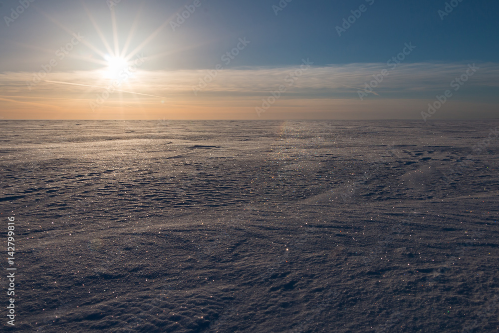Low sun over frozen winter sea.