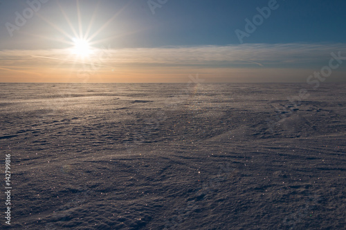 Low sun over frozen winter sea.