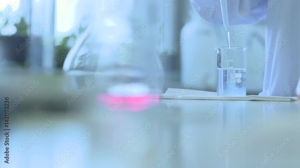 Scientist Pipetting Liquid Into Flask and finding cure. Scientist Pipetting Liquid Into Flask and finding cure.