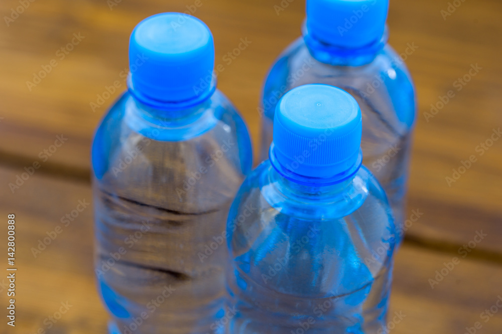 water in plastic bottles on a wooden table water in plastic bottles on a wooden table