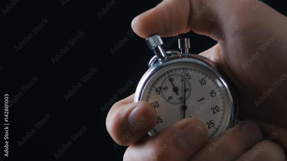 One person starting up a stopwatch at black background