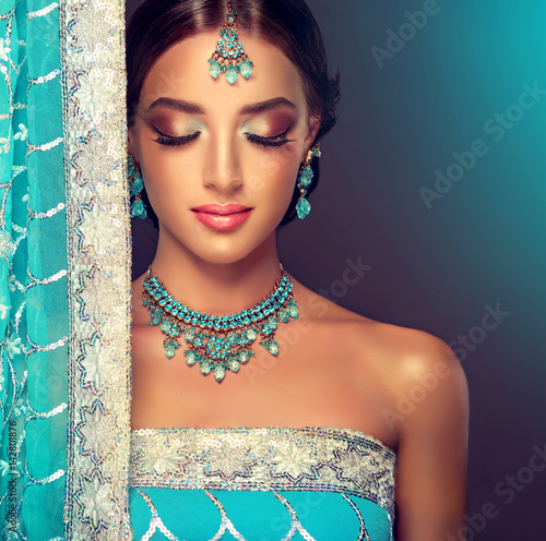 Portrait  smiling of beautiful indian girl. Young indian woman model with blue kundan jewelry set . Traditional Indian costume saree . 