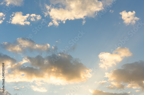 Dramatic sky background include sunset or sunrise, abstract cloud look fluffy. Represent weather, wind, heaven, freedom and god. Colorful with yellow, orange and blue color at evening in autumn. 