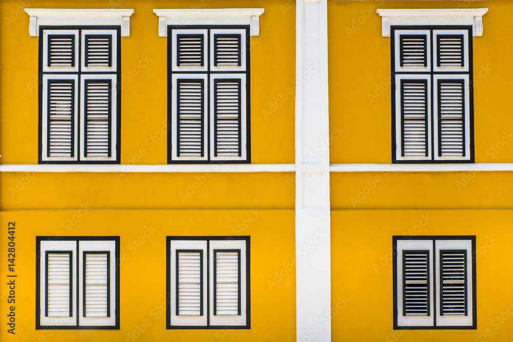  Vibrant yellow exterior building facade with windows