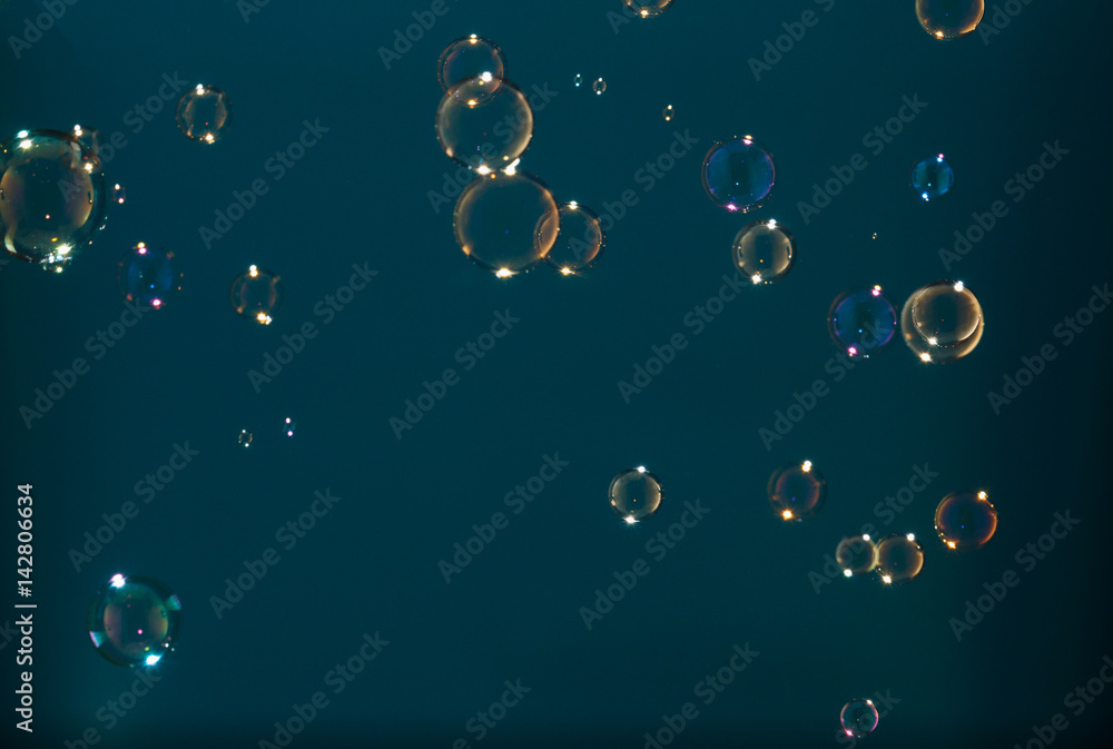 Rainbow soap bubbles on a cyan background