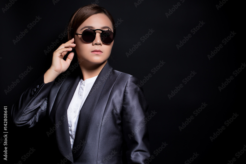 Fototapeta premium Seriously businesswoman wearing sun glasses on isolated background