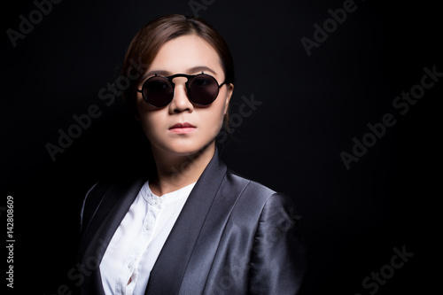 Seriously businesswoman wearing sun glasses on isolated background