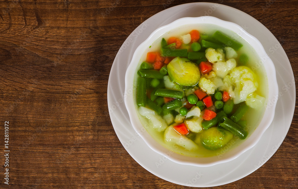 Fresh vegetable soup in bowl on wooden table with copy space. top view Fresh vegetable soup in bowl on wooden table with copy space. top view
