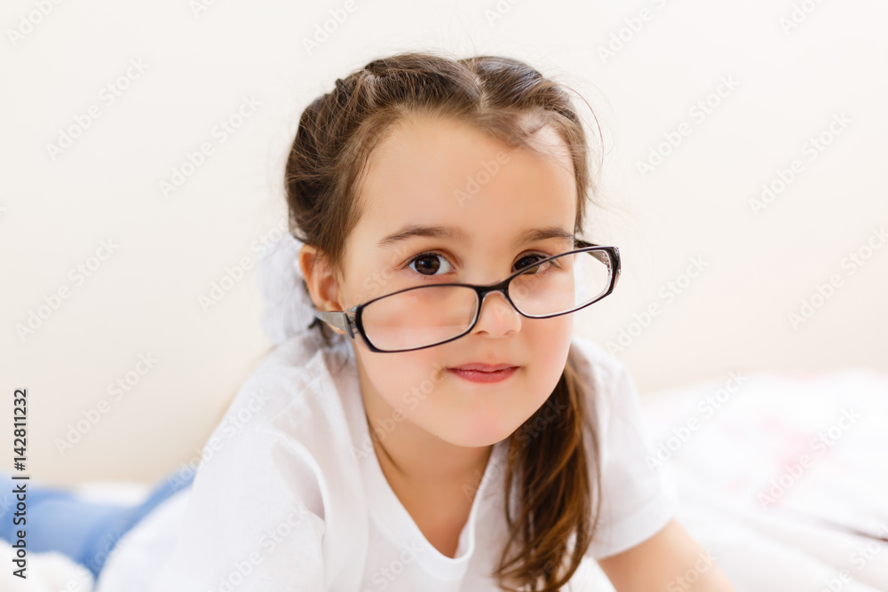 education, school, technology and internet concept - little student girl in black eyeglasses with tablet pc computer at school education, school, technology and internet concept - little student girl in black eyeglasses with tablet pc computer at school