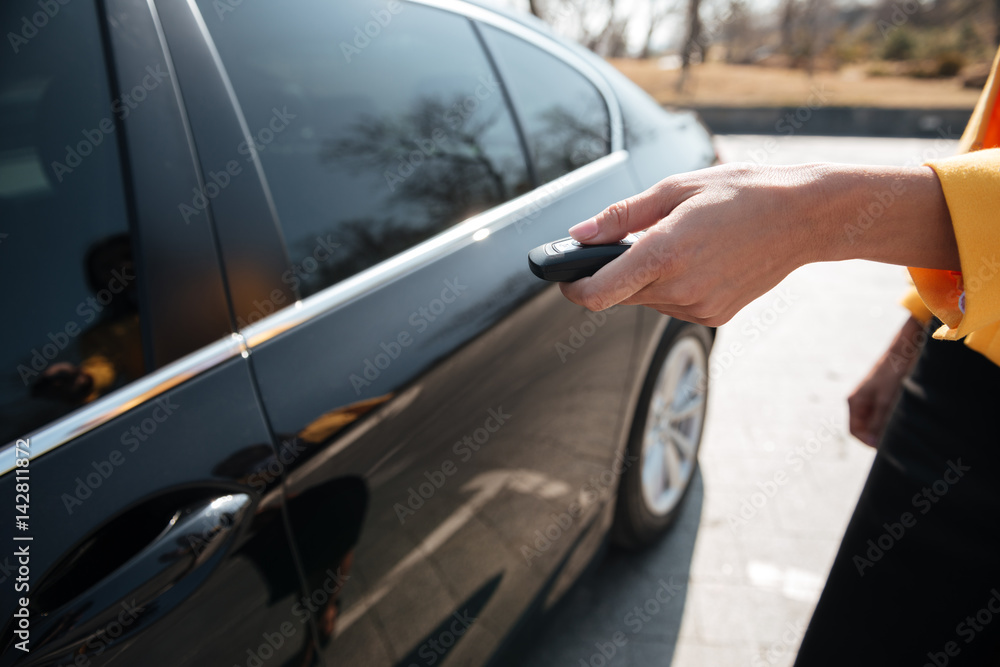 Woman turning on alarm and closing the door of car Woman turning on alarm and closing the door of car