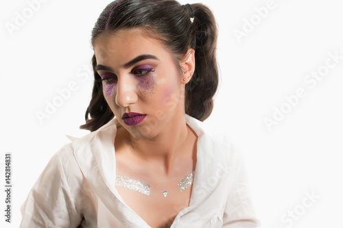 Young girl with two pony tails and artistic make up on  white  background 