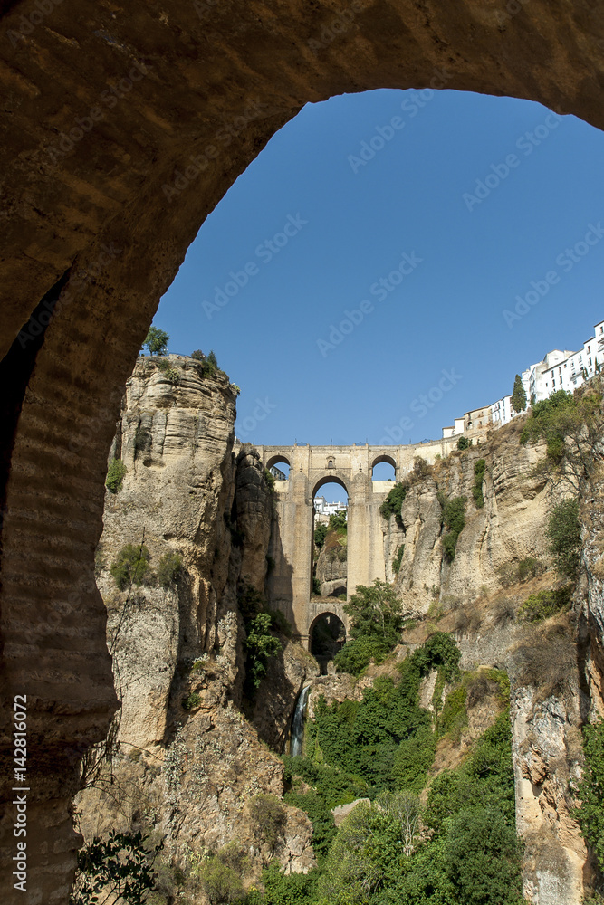 sight of an Arab arch and of the new bridge in the Ronda town, Malaga, Andalusia in Spain