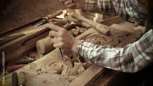 Wood carving. Carver with chisel and hammer. A skillful craftsman working on a panel of wood carve decoration