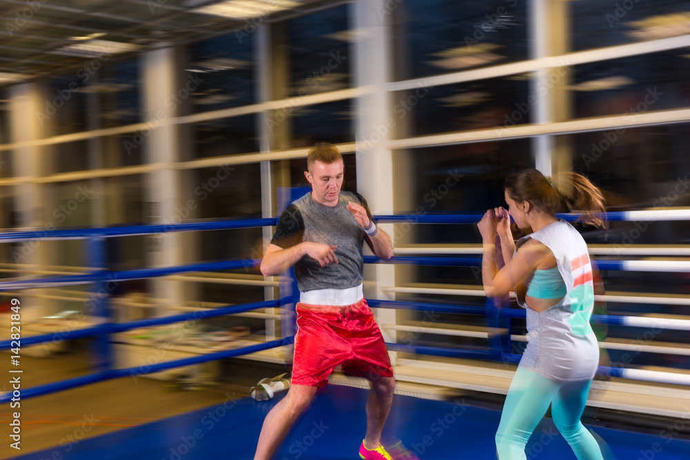 Male and female in action practicing boxing