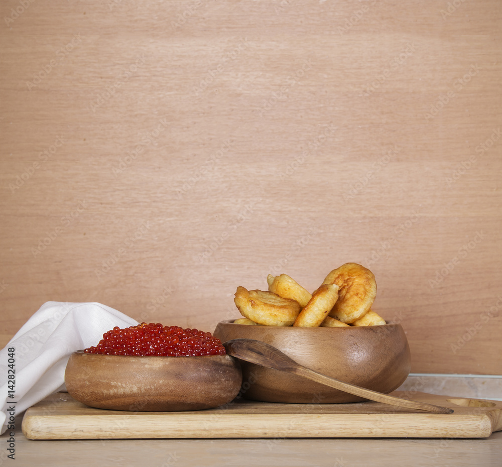 Wooden background with salmon caviar and pancakes Russian cuisine