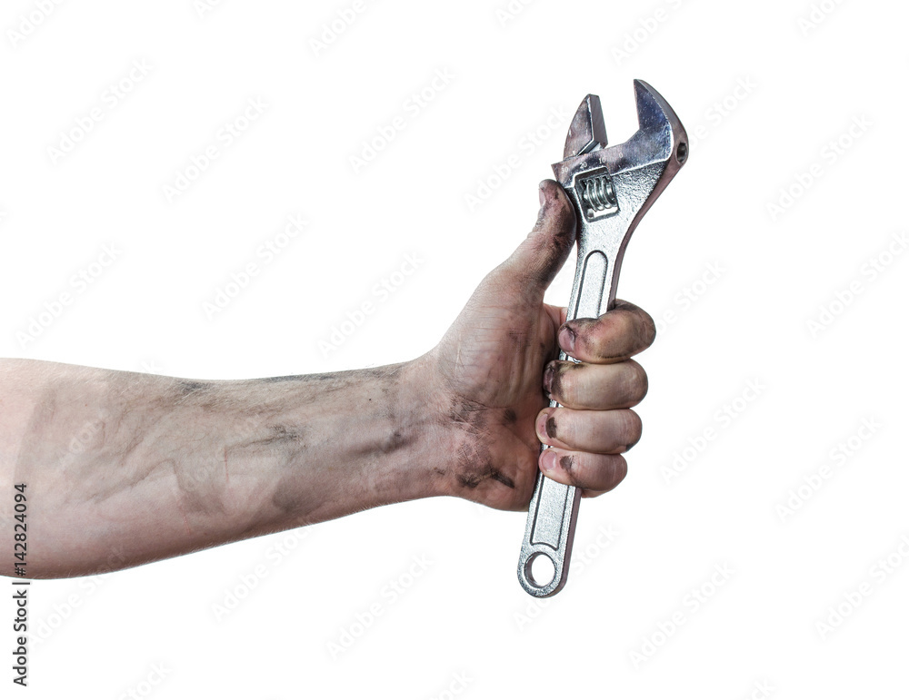 Oily hands of mechanic holding a wrench. Isolated background. Oily hands of mechanic holding a wrench. Isolated background.