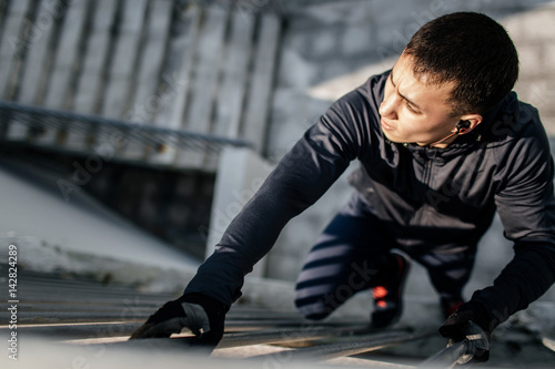 A young man climbs a sheer wall in urban conditions. Workahouse. Parkour. Extreme