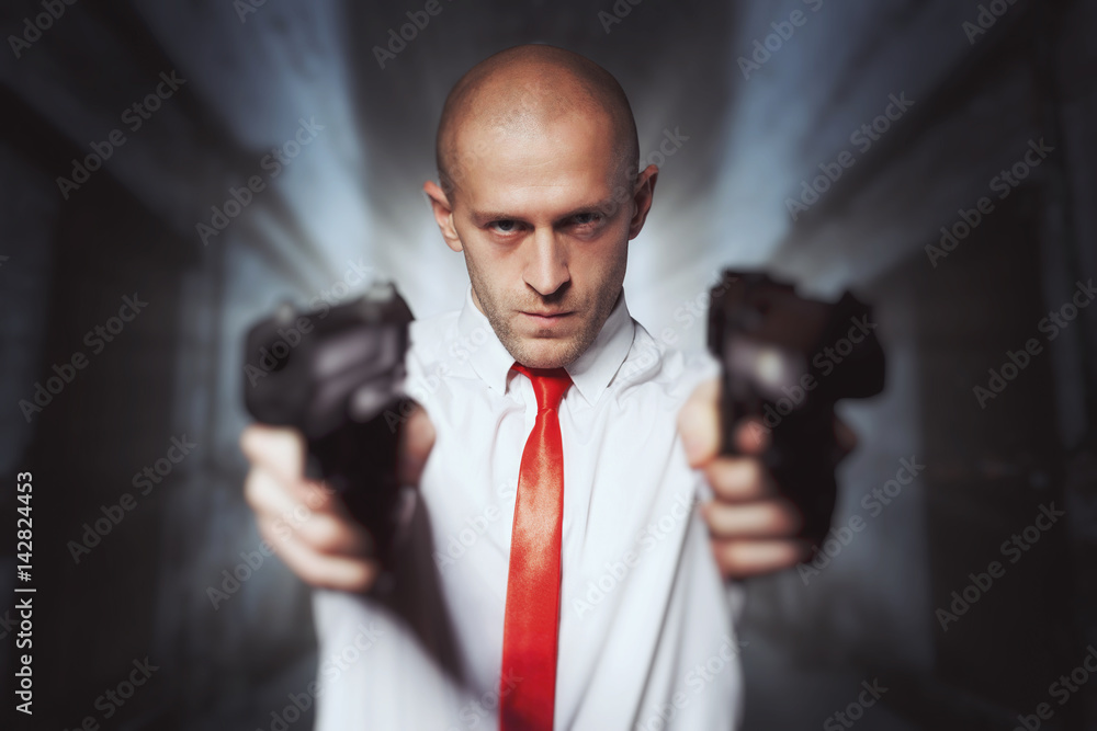 Bald hired killer in red tie aims a pistols Bald hired killer in red tie aims a pistols