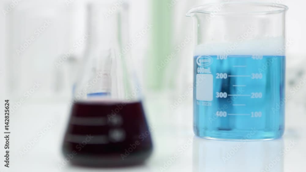 Panning view of glass beakers filled with liquid Panning view of glass beakers filled with liquid