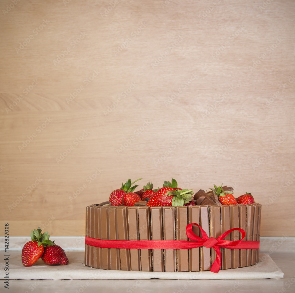 Old paper background with chocolate cake with fresh strawberry
