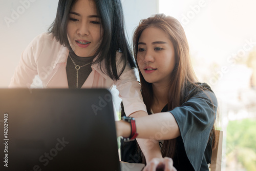 Young Asian women workers working together in office