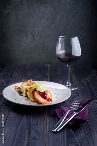 Goose liver with cherry sauce and apples and a glass of wine