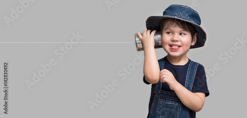 Little boy holding a can with a cord