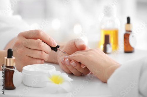 Young woman getting manicure in spa salon