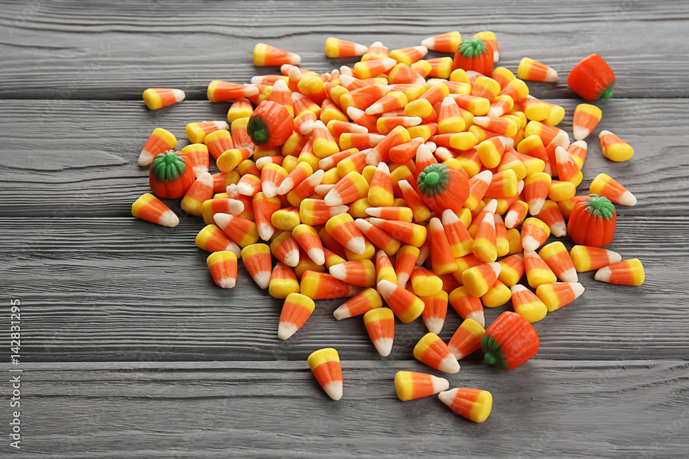 Tasty Halloween candies on wooden background