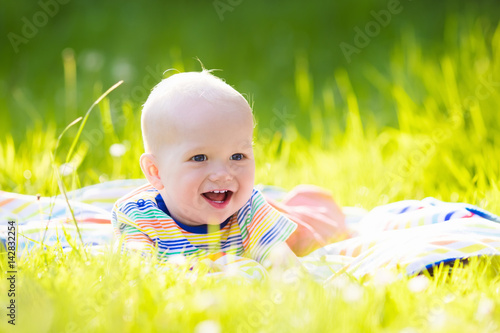 Baby boy with apple on family garden picnic photo
