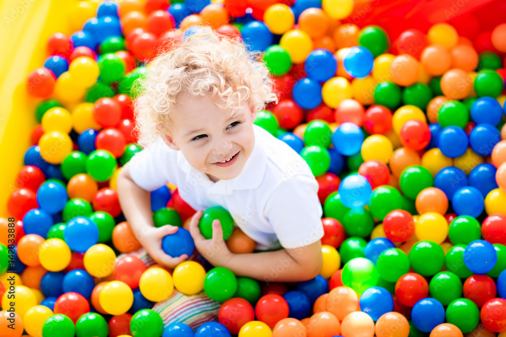 Child playing in ball pit on indoor playground Child playing in ball pit on indoor playground
