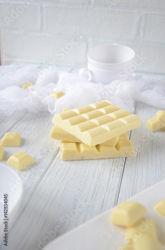 Pieces of white chocolate, black background, selective focus