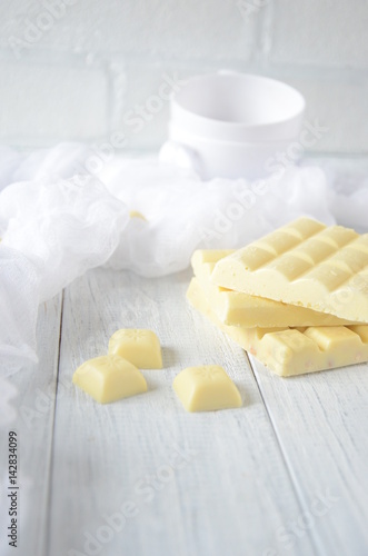 Pieces of white chocolate, black background, selective focus