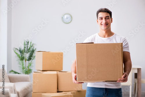 Young man moving boxes at home