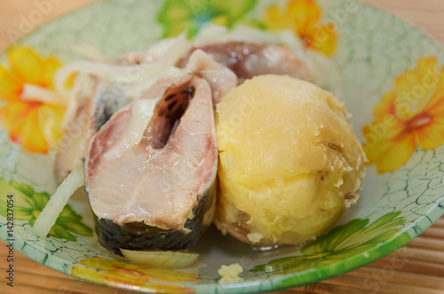 Pieces of pickled herring with onions and potatoes. Close-up.