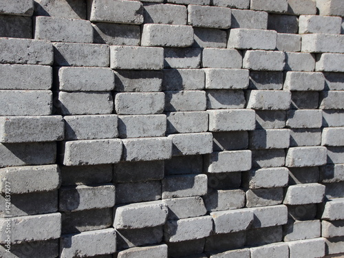 Uneven Stack of Grey Concrete Road Bricks