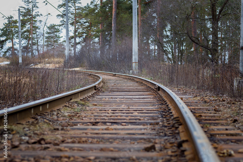 The old railway track on wooden sleepers, in the woods, in the autumn,