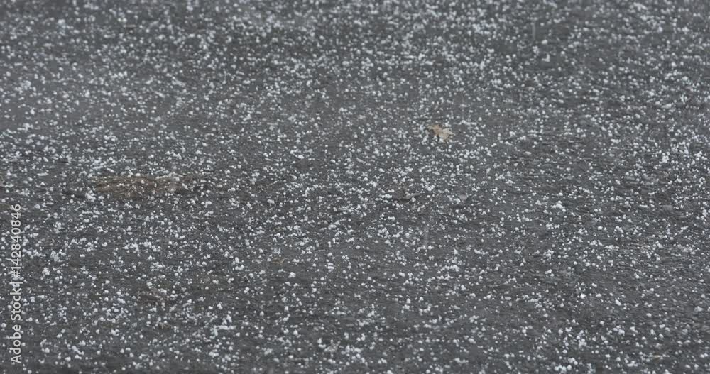 Slow motion of hailstones falling and bouncing on asphalt in early spring handheld, 4k 60fps prores footage Slow motion of hailstones falling and bouncing on asphalt in early spring handheld, 4k 60fps prores footage