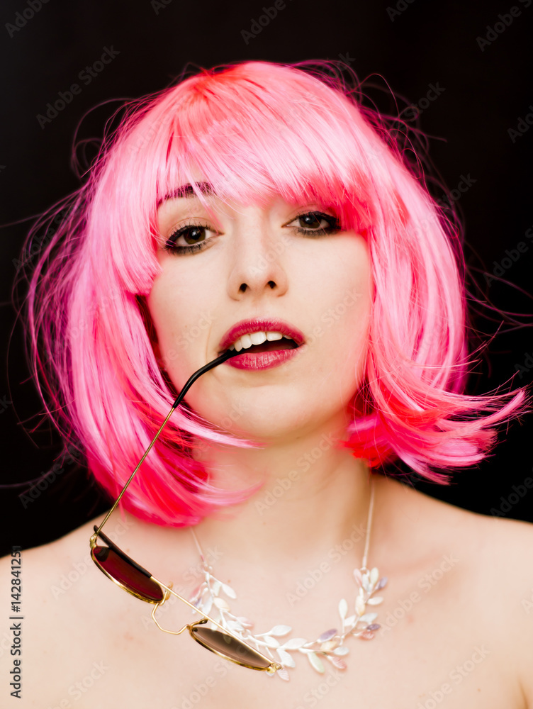 Fototapeta premium Beauty Woman With Pink Wig And Sunglasses Over Black Background