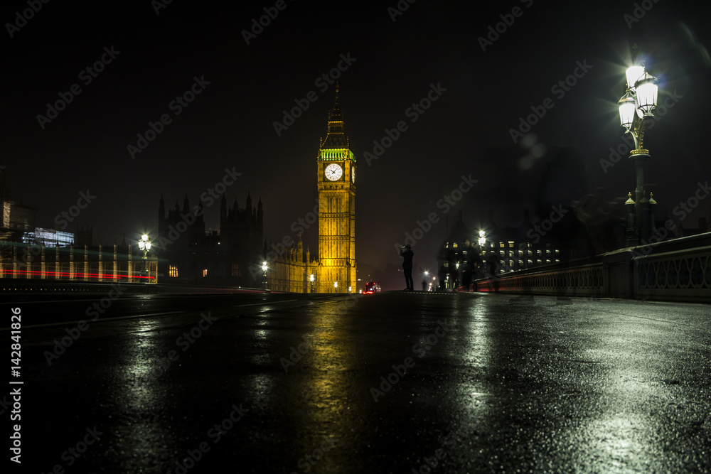 Big Ben from Westminster Bridge at night and a tourist making photo, London