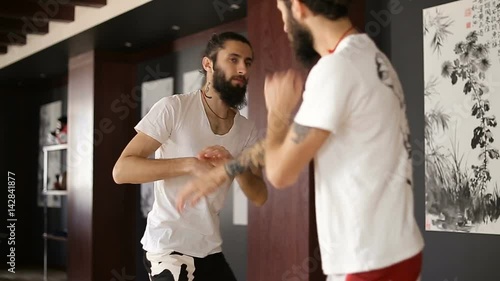 Twin brothers practice in Chinese martial arts in the training hall photo