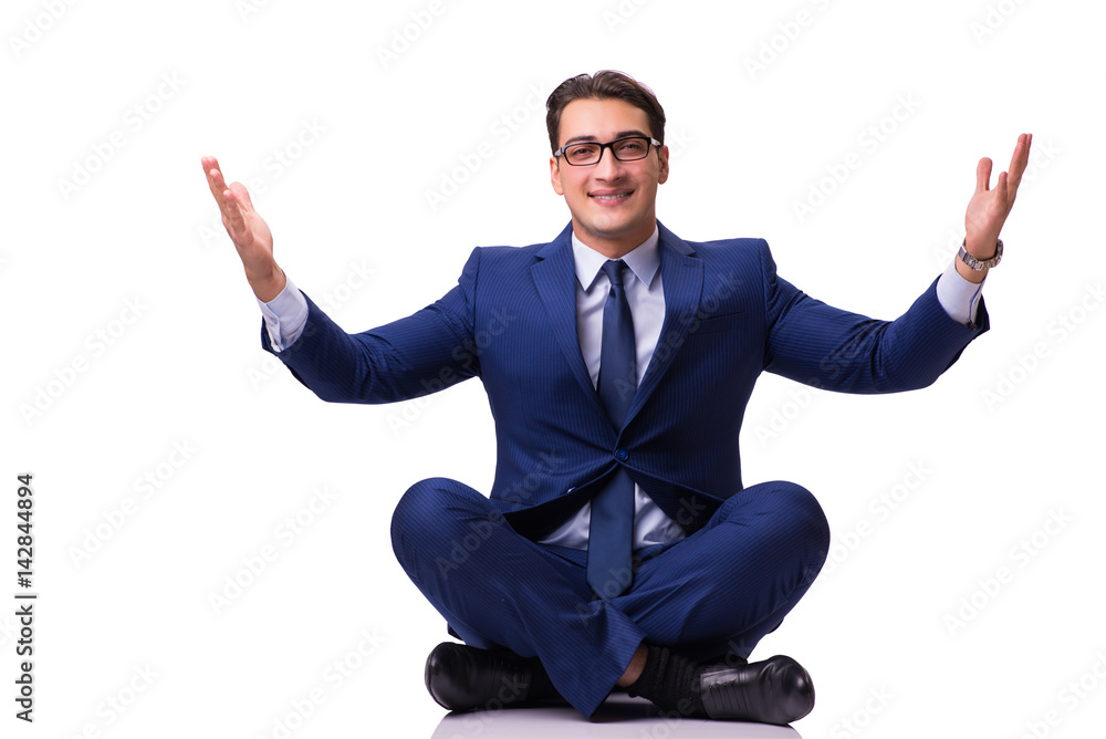 Businessman meditating on the floor isolated on white