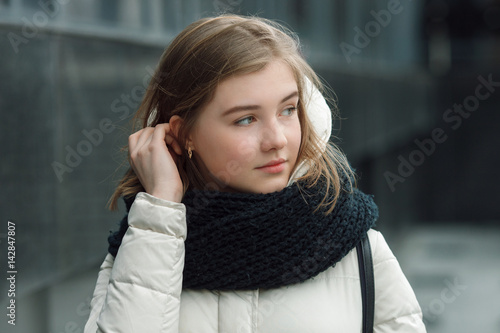 Foto City portrait of young beautiful blonde stylish girl posing in spring fall outdoors in white coat black knitted scarf