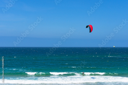 Kitesurfing ocean waves on sunny day