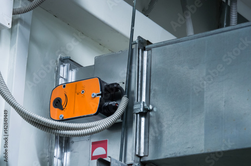 Slika na platnu Orange damper actuator installed on the ductwork of the central ventilation syst