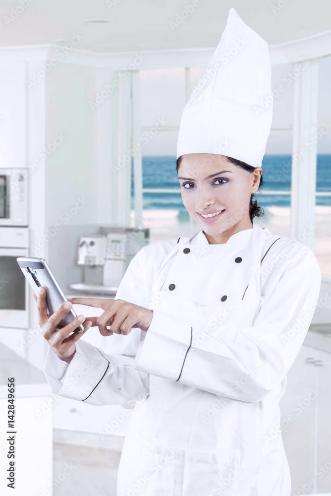 Female baker using cellphone in the kitchen