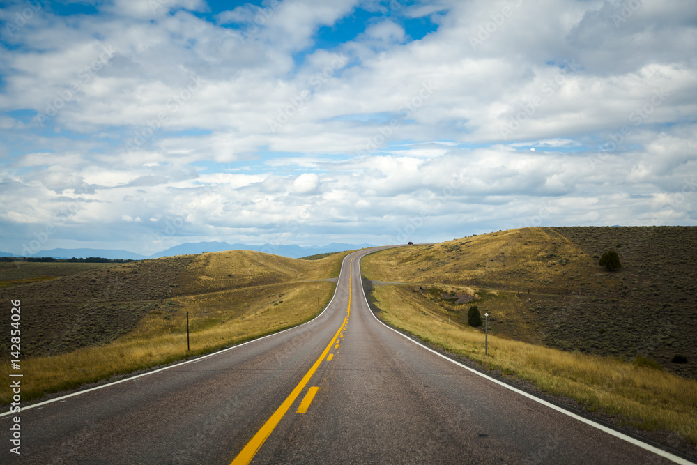 Open road with blue sky and clouds, Montana