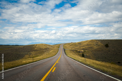 Open road with blue sky and clouds, Montana