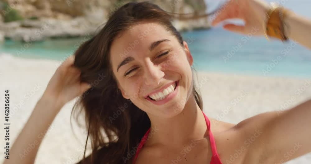 Close up portrait of beautiful young woman smiling laughing tying up hair on tropical beach slow motion Close up portrait of beautiful young woman smiling laughing tying up hair on tropical beach slow motion